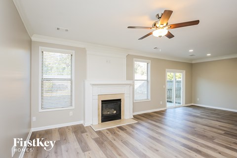 A spacious room with a fireplace and a ceiling fan.
