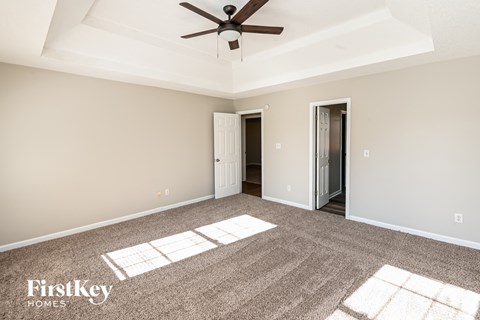 a living room with carpet and a ceiling fan