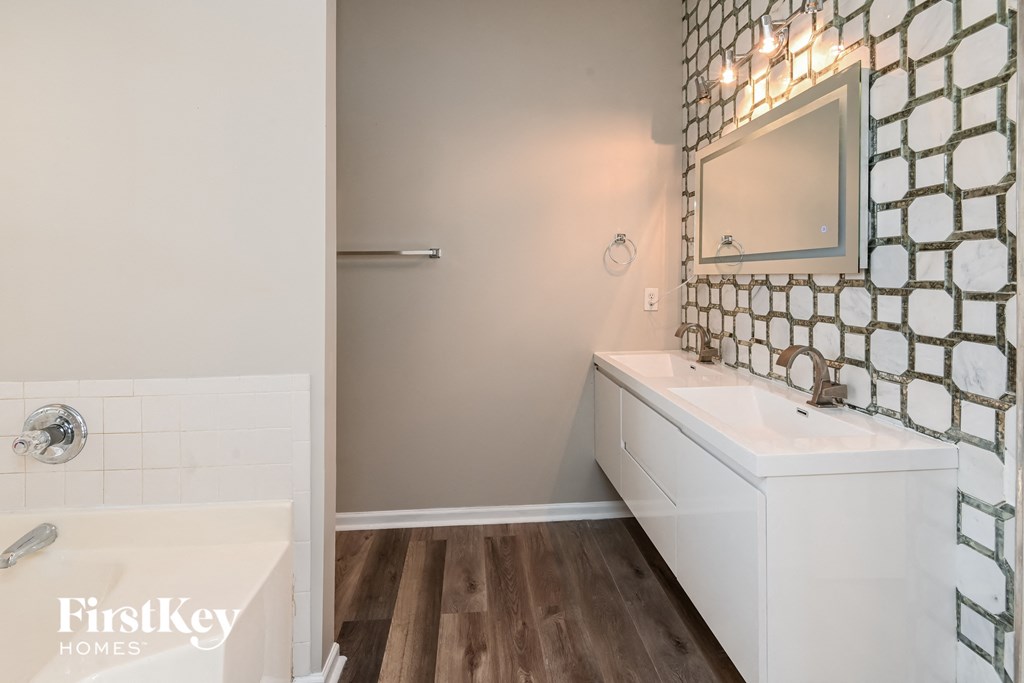 a bathroom with a white sink and a tub and a mirror