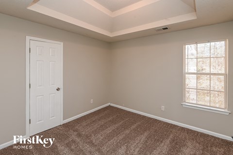 a bedroom with a white door and a carpeted floor