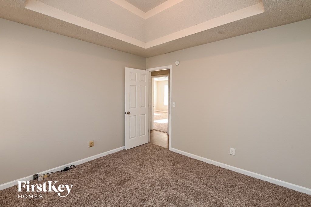 a bedroom with a carpeted floor and a door to a closet