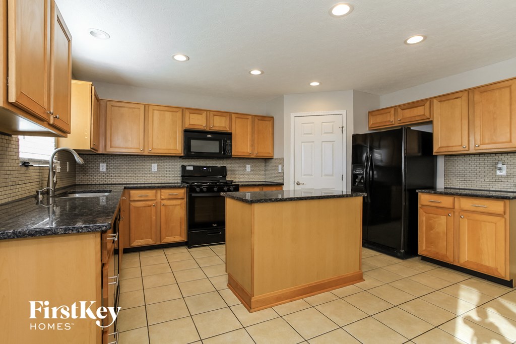 a large kitchen with black appliances and wooden cabinets