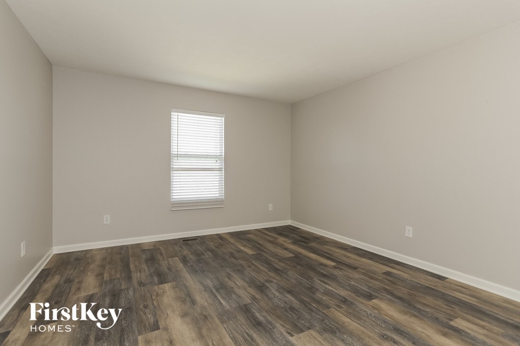 the living room of a house with wooden floors and a window