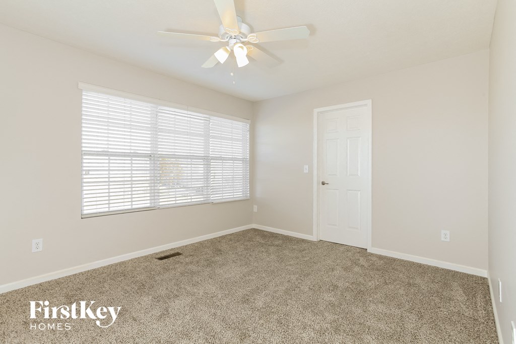 a bedroom with a ceiling fan and a window