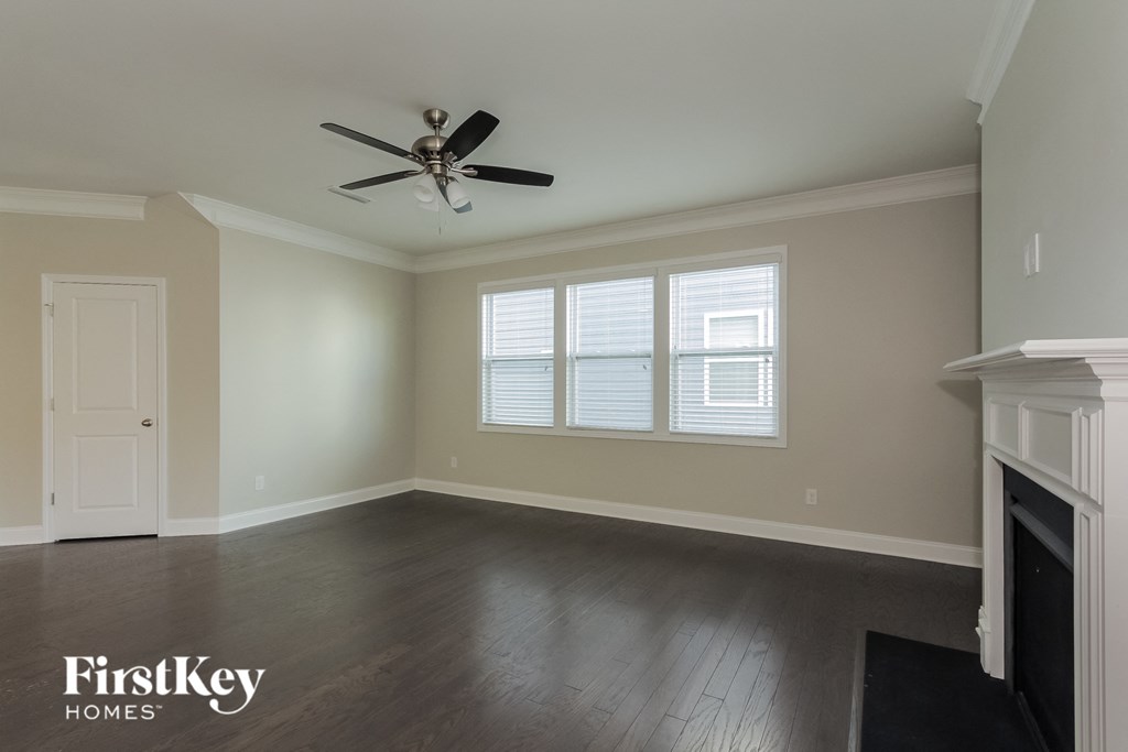 A spacious room with a fireplace and a ceiling fan.