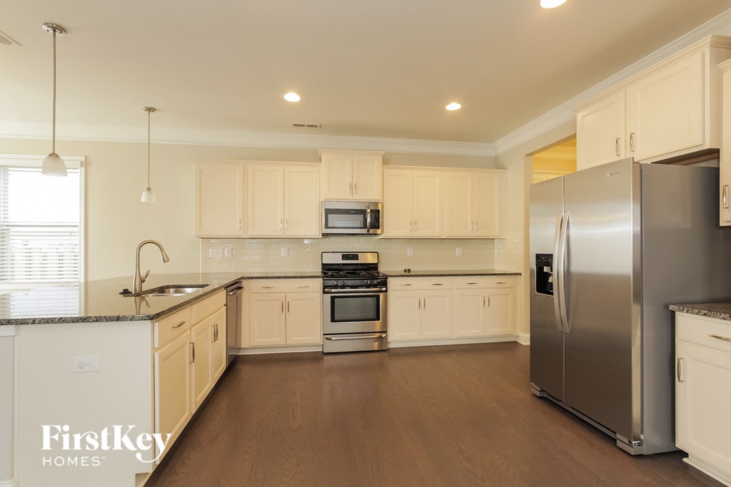 A kitchen with wooden cabinets and a stainless steel refrigerator.
