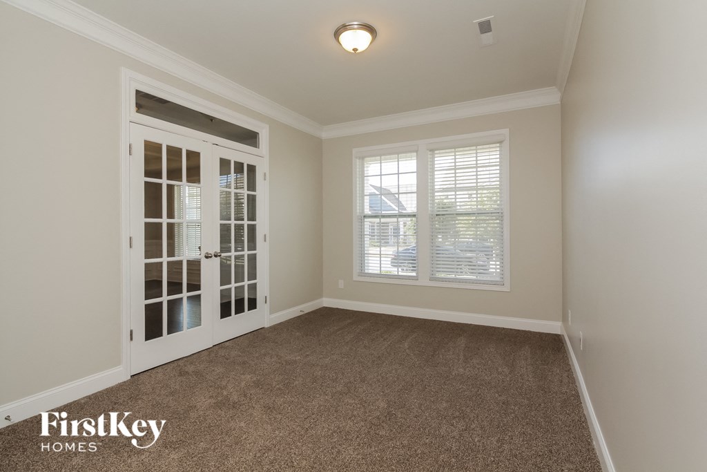 A room with a carpeted floor and a sliding glass door.