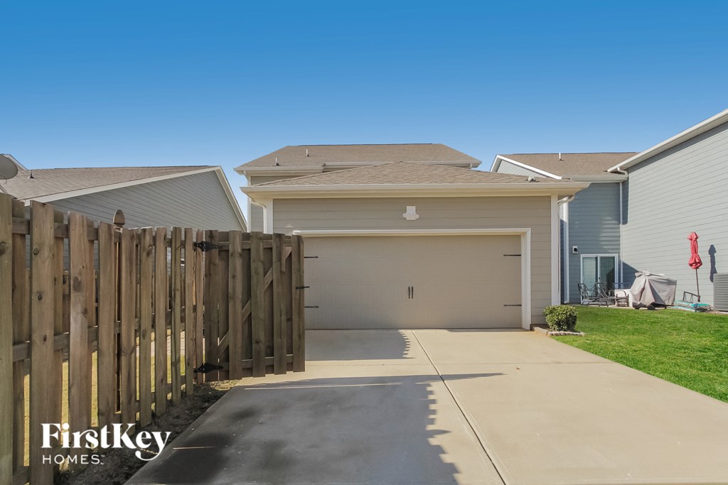 A house with a garage and a wooden fence in front.