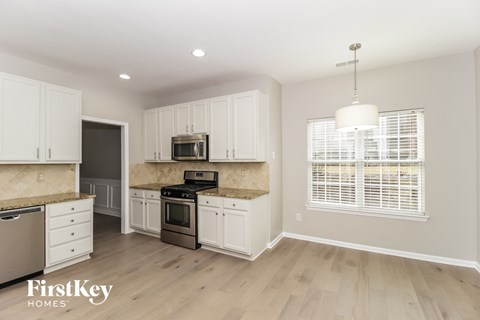 A kitchen with white cabinets and a wooden countertop.