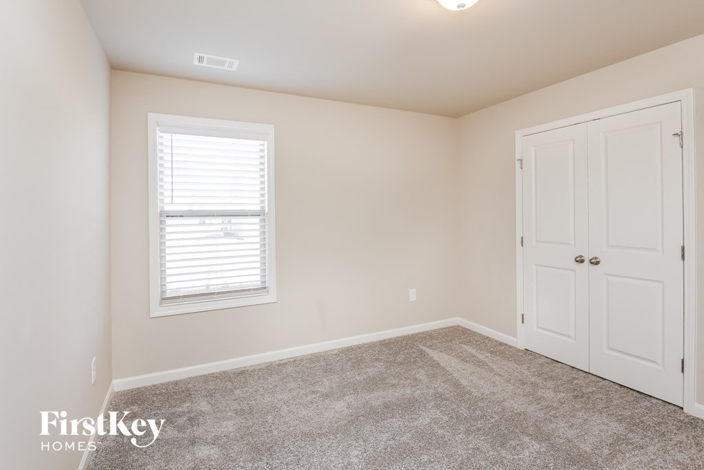 a bedroom with a carpeted floor and a white door