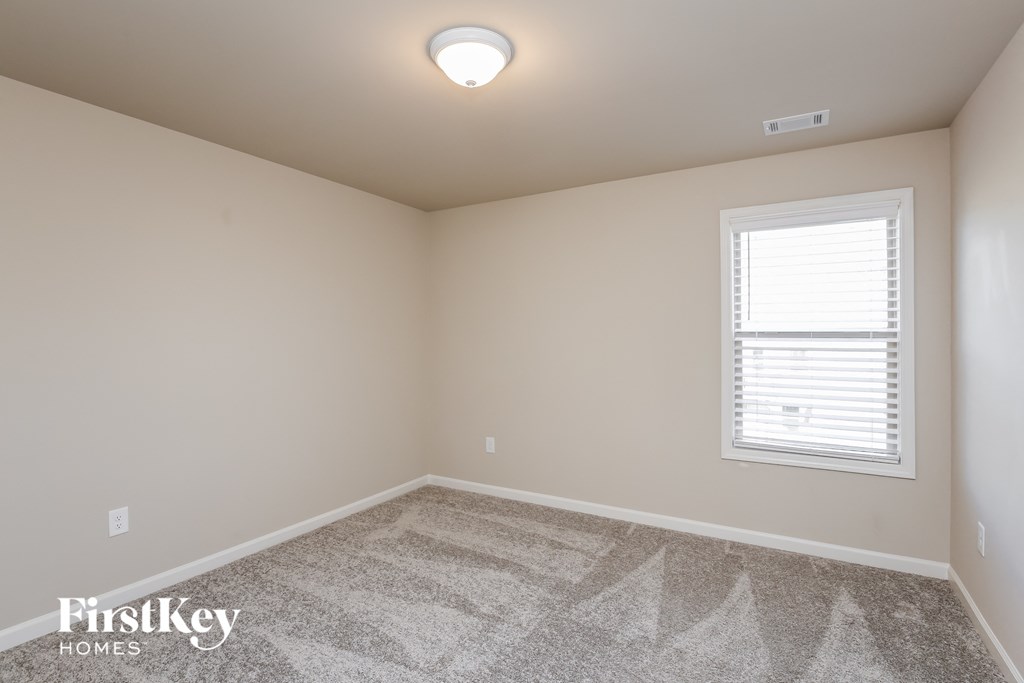 a bedroom with a carpeted floor and a window