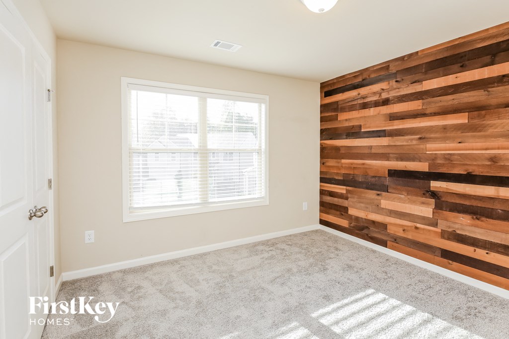 a living room with a wood accent wall and a window