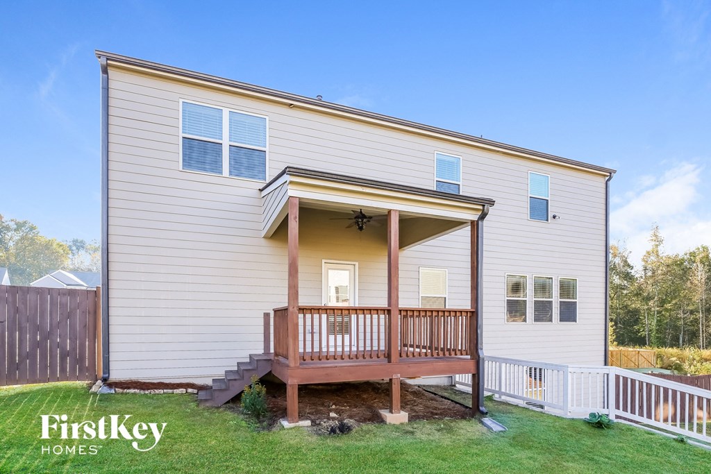 the exterior of a white house with a porch and a deck