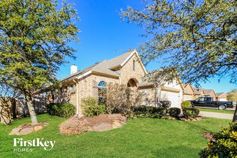 a home with a lawn and trees in front of it