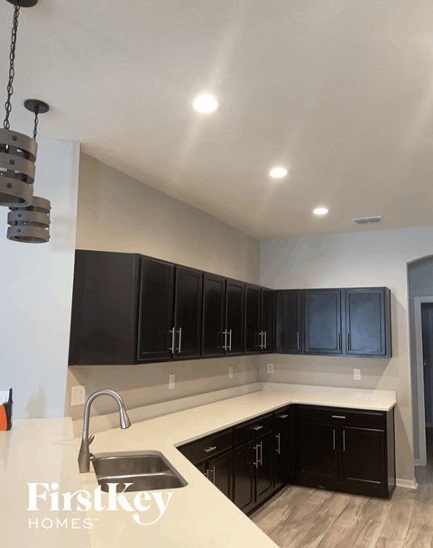 A kitchen with black cabinets and a white countertop.