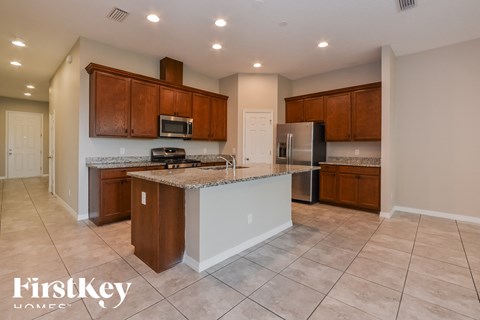 A kitchen with brown cabinets and a white island.