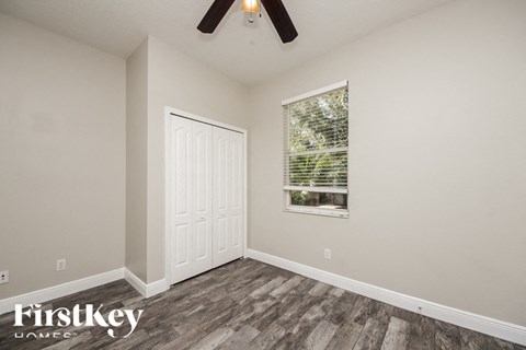 an empty bedroom with a window and a white door