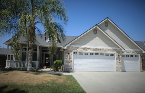 a house with a white garage door and a palm tree