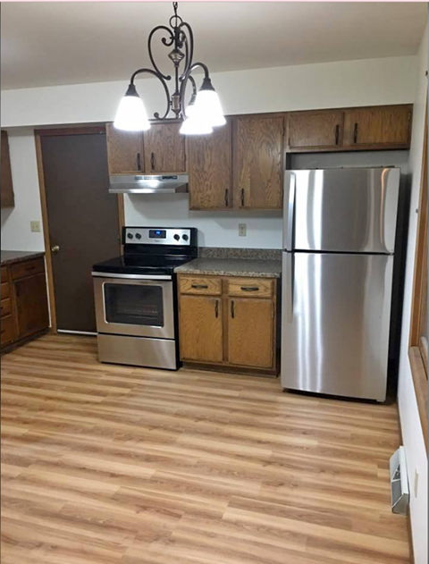a kitchen with stainless steel appliances and wooden floors