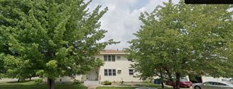 a white building with trees in front of it