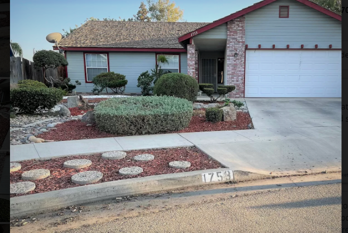 a house with a curb appeal with a garden and a driveway