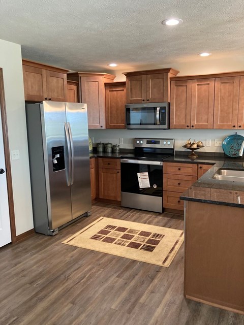 A kitchen with wooden cabinets and a refrigerator.