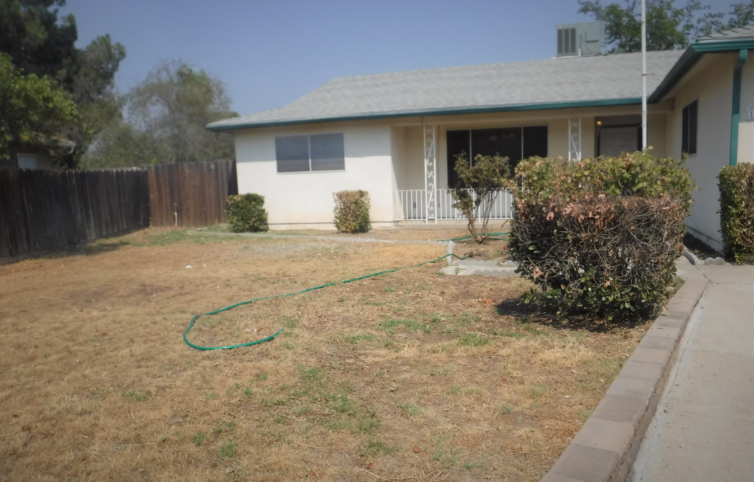 a garden hose in a yard in front of a house