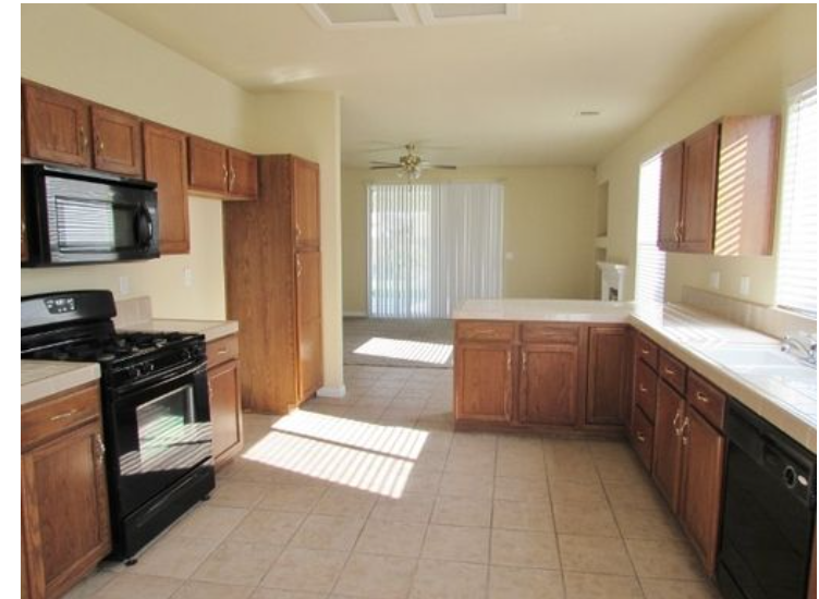 an empty kitchen with a stove and a microwave
