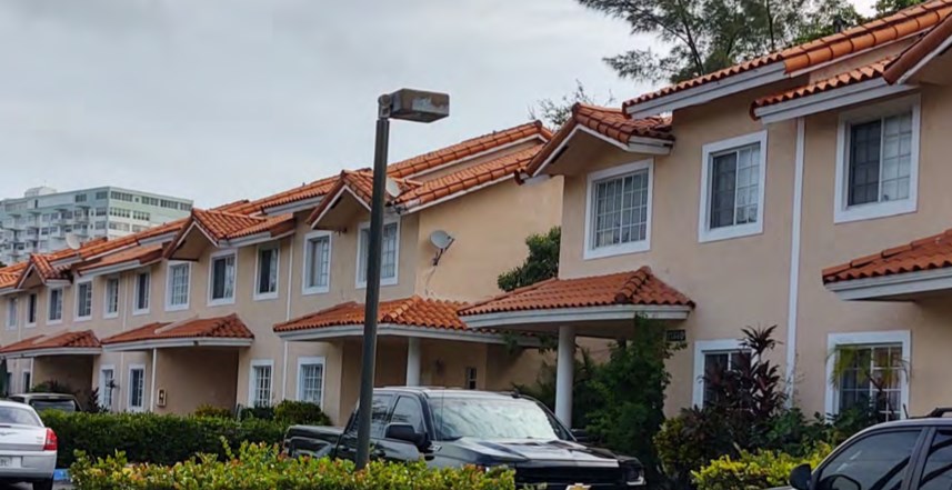 a row of houses with cars parked in front of them