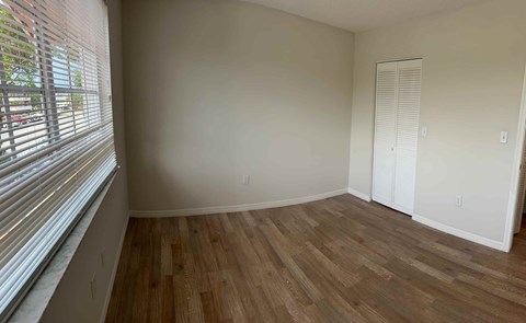 a living room with wood floors and a large window