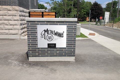 a monument sign on the side of a sidewalk