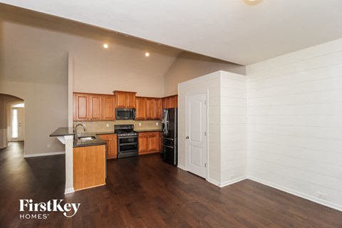 a kitchen with wood floors and wooden cabinets