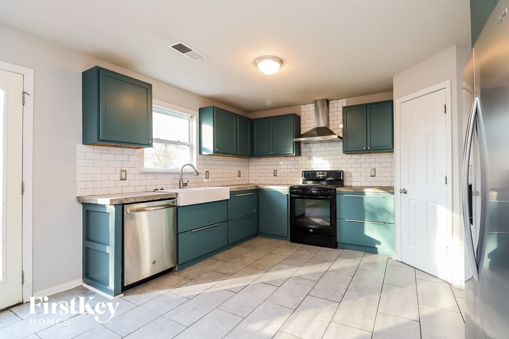 a kitchen with blue cabinets and a sink and a refrigerator