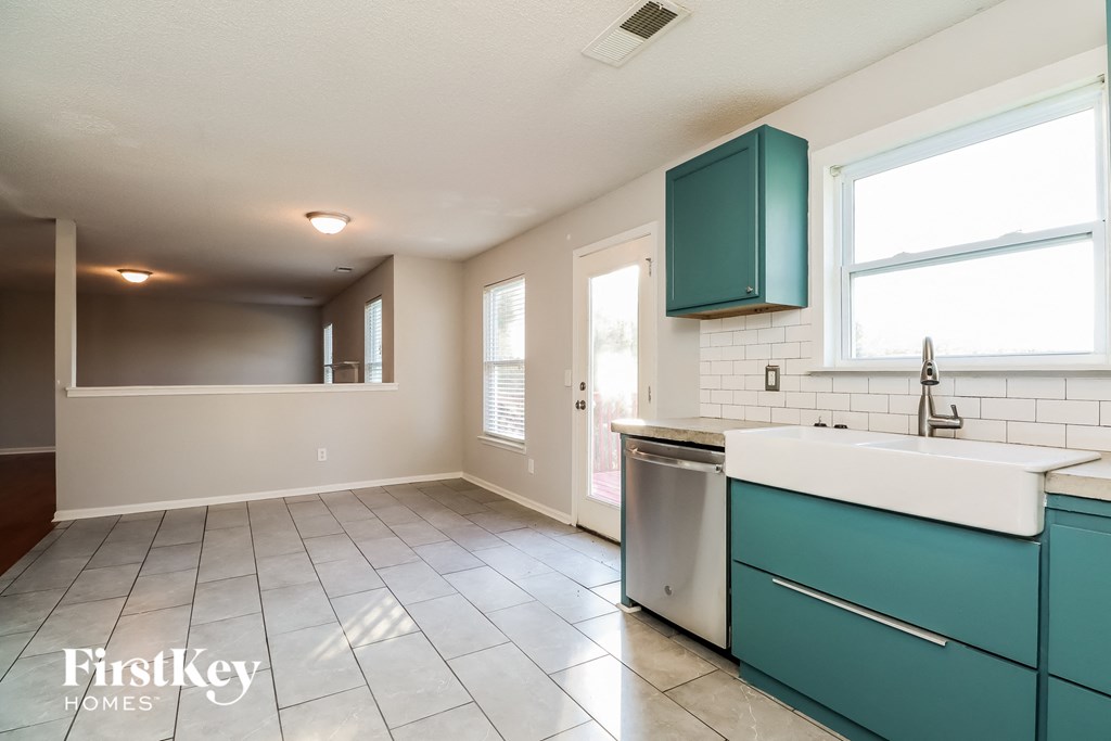 an empty kitchen with green cabinets and a white counter top