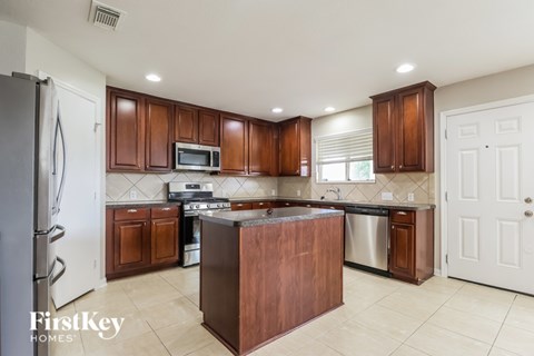 A kitchen with brown cabinets and a refrigerator.