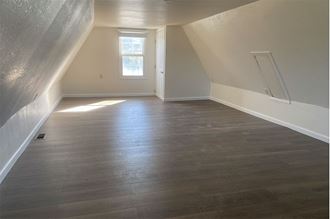 a empty room with wood floors and a window