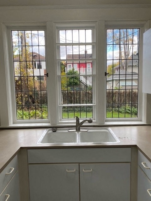 a kitchen with a sink and three windows