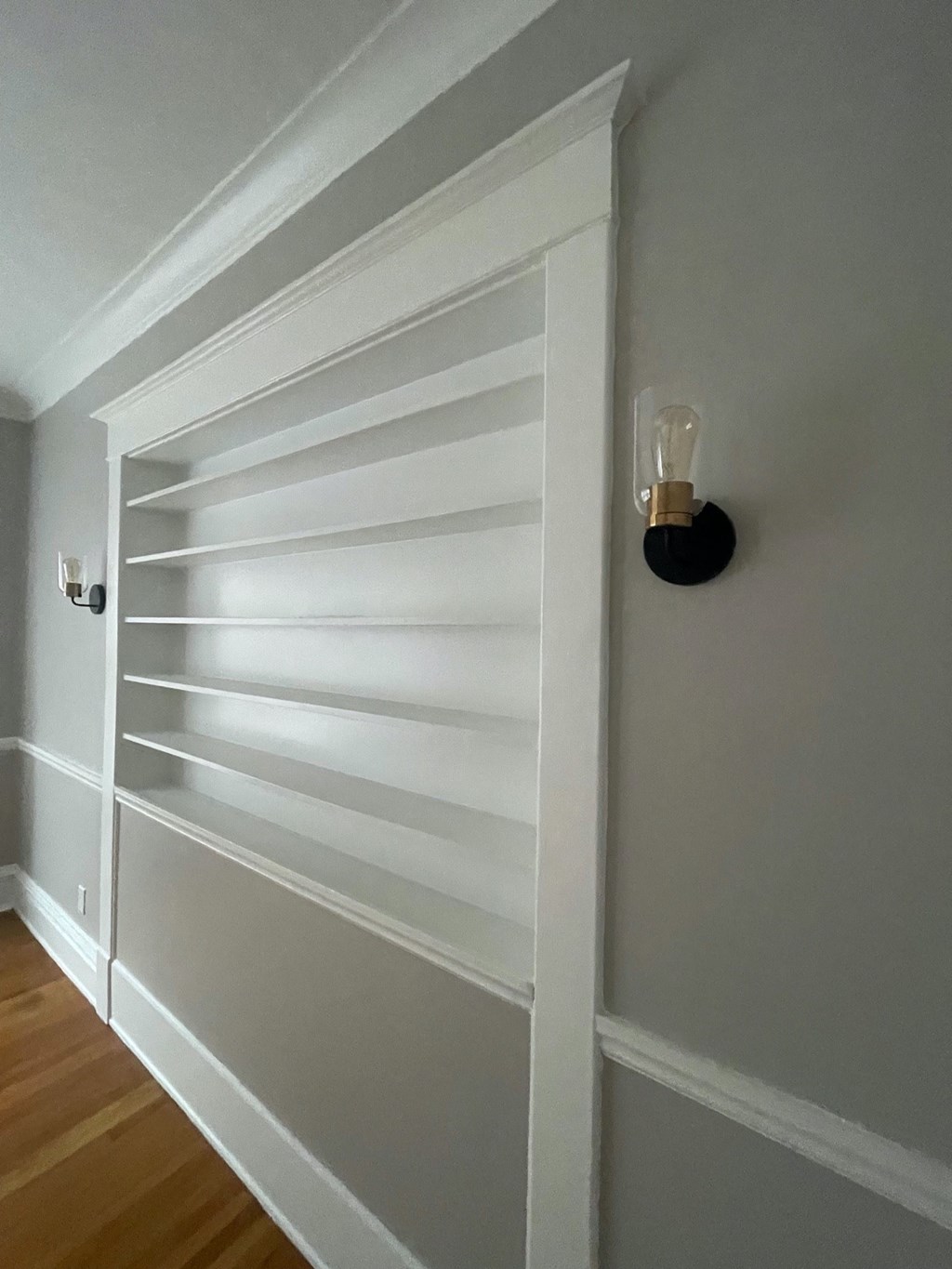 a wall with a white door with a light on it