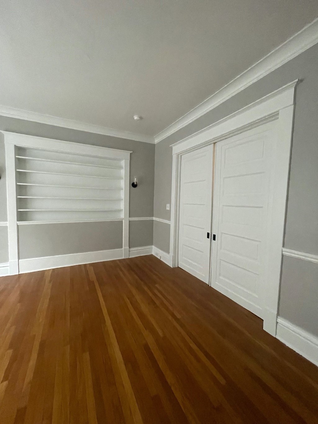 a living room with wooden floors and white closet doors