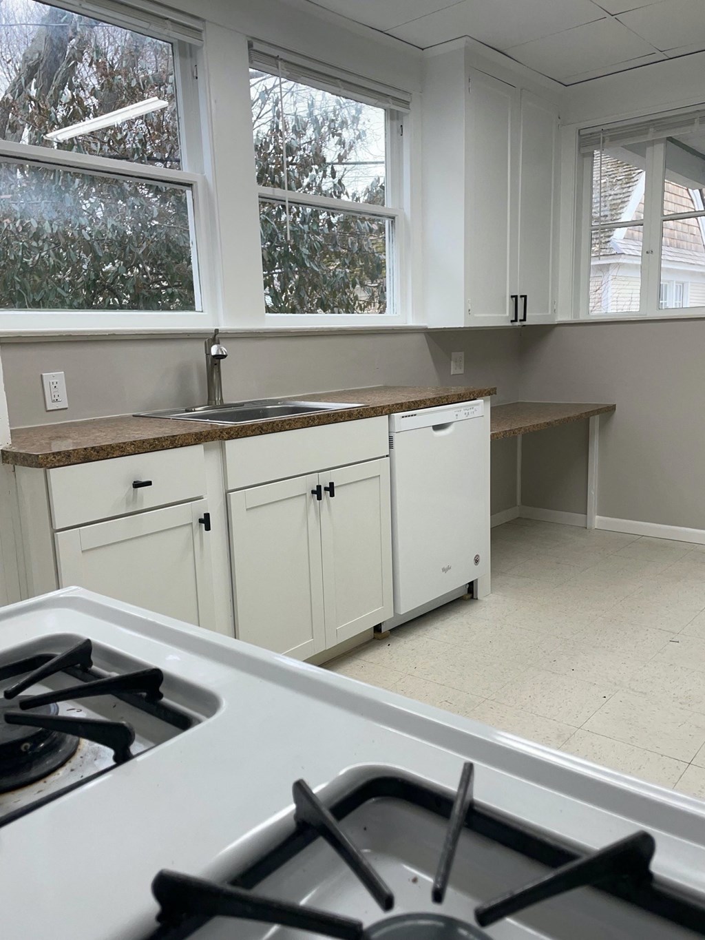 a kitchen with white cabinets and a stove and a sink