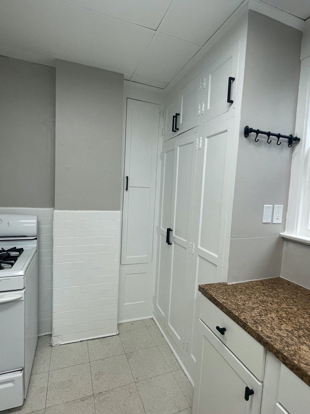 a kitchen with white cabinets and white appliances and a counter top
