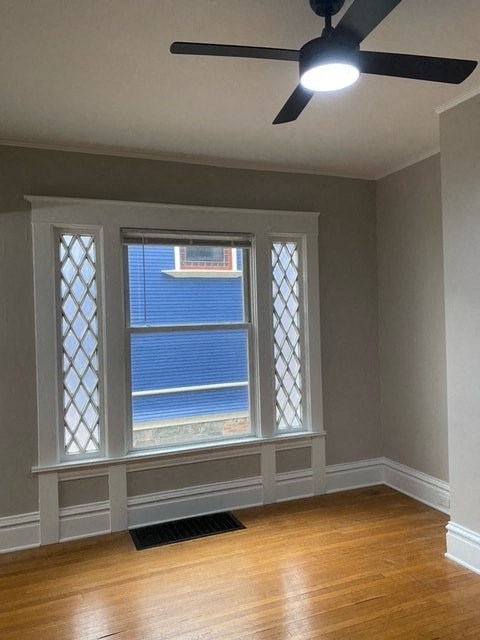 a living room with a window and a ceiling fan
