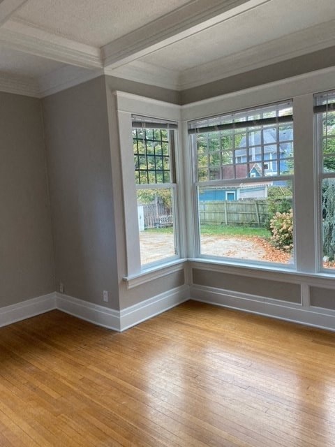 a living room with three windows and a wooden floor