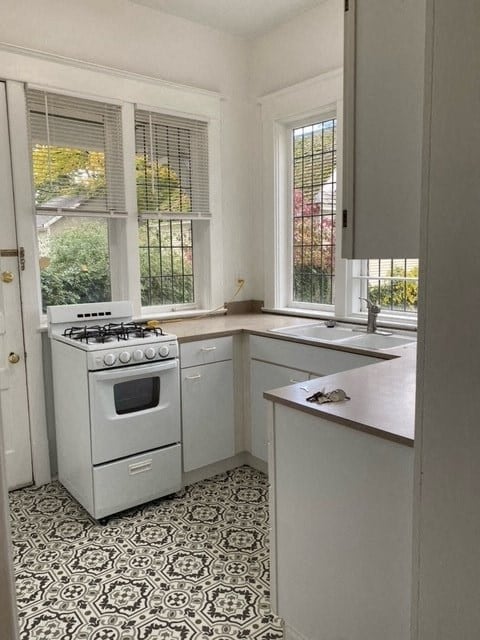 a white kitchen with a stove and a window