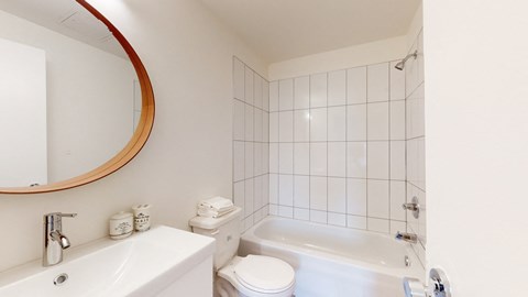 a white bathroom with a tub and a toilet and a sink