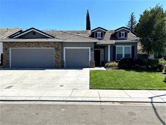A house with a grey garage door and a brown roof.