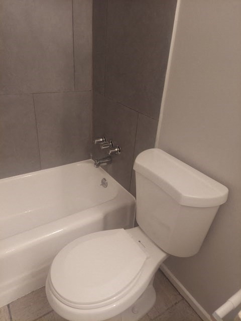 a bathroom with a white toilet and a bath tub