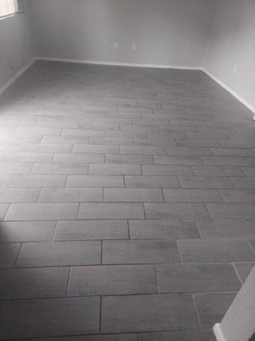 a empty room with a tile floor and a white wall