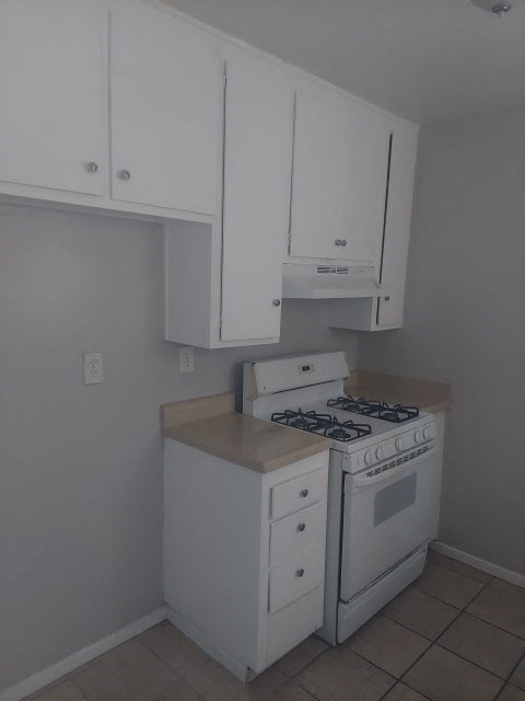 a kitchen with a stove and white cabinets