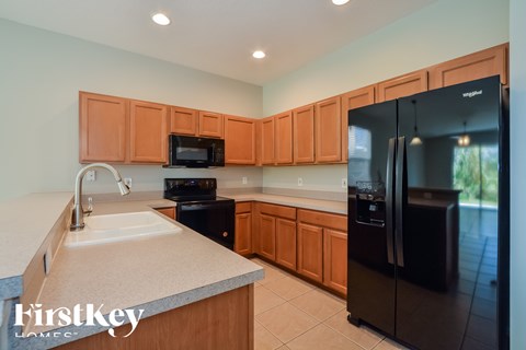 A kitchen with wooden cabinets and black appliances.